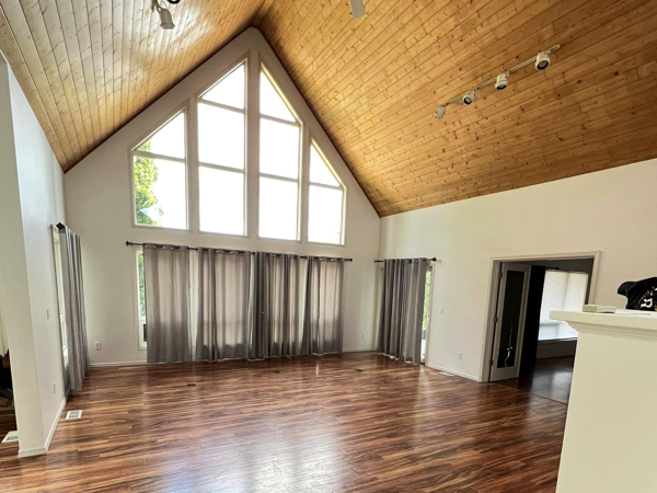 Spacious living room with freshly painted white walls, vaulted